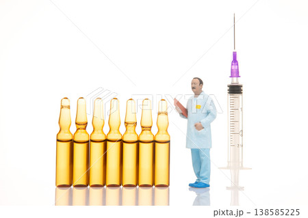 Miniature figures of a doctor preparing for a vaccine injection using small vials  138585225