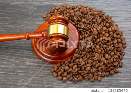 Coffee beans surround a gavel on a wooden surface during a legal discussion about coffee regulations Coffee beans surround a gavel on a wooden surface during a legal discussion about coffee regulations 138585476