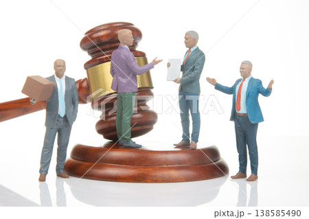Figures represent legal discussion with gavel in background during courtroom scene 138585490