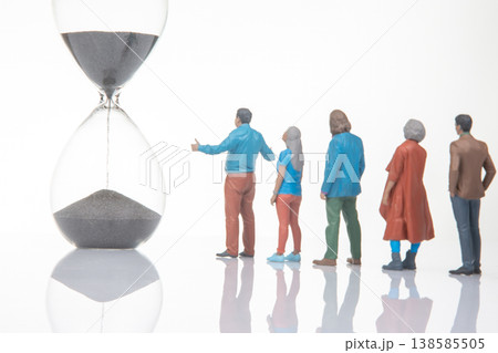 People standing in line next to a large hourglass with black sand during the daytime inside People standing in line next to a large hourglass with black sand during the daytime inside 138585505