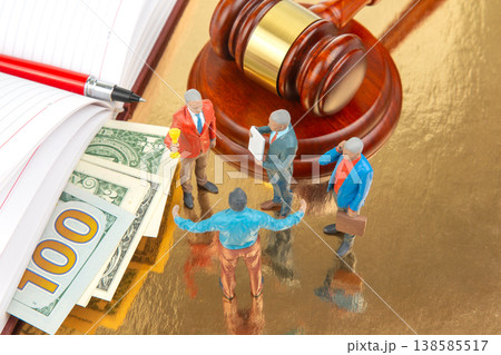 Legal team discusses negotiation over money near a gavel and documents on a desk at an office  138585517