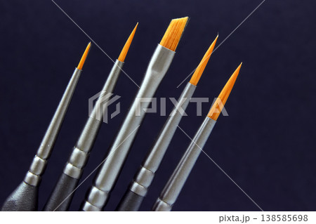 Different types of paintbrushes displayed against a dark background for art projects and painting 138585698