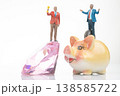 Miniature people hold trophies as they stand on a large diamond and a piggy bank in creative  138585722