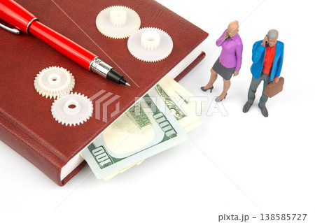 Miniature people talking near a book with money and gears on a white surface during daylight hours Miniature people talking near a book with money and gears on a white surface during daylight hours 138585727