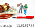 Miniature people carry boxes next to money and a gavel during a business discussion in a courtroom  138585728