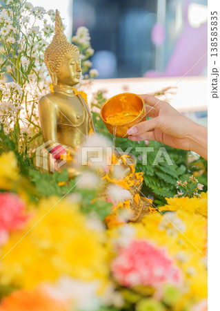 Happy Songkran festival day in Thailand or Thai Happy New Year. hand pouring water on golden Buddha statue with flowers and garland in. Holiday and culture concept Happy Songkran festival day in Thailand or Thai Happy New Year. hand pouring water on golden Buddha statue with flowers and garland in. Holiday and culture concept 138585835