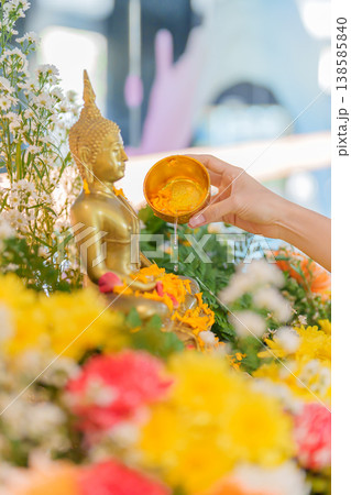 Happy Songkran festival day in Thailand or Thai Happy New Year. hand pouring water on golden Buddha statue with flowers and garland in. Holiday and culture concept 138585840