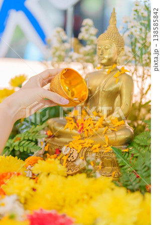 Happy Songkran festival day in Thailand or Thai Happy New Year. hand pouring water on golden Buddha statue with flowers and garland in. Holiday and culture concept Happy Songkran festival day in Thailand or Thai Happy New Year. hand pouring water on golden Buddha statue with flowers and garland in. Holiday and culture concept 138585842