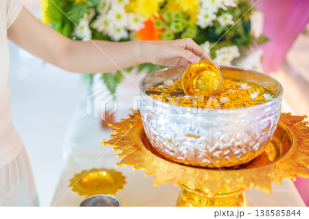 Happy Songkran festival day in Thailand or Thai Happy New Year. hand pouring water on golden Buddha statue with flowers and garland in. Holiday and culture concept Happy Songkran festival day in Thailand or Thai Happy New Year. hand pouring water on golden Buddha statue with flowers and garland in. Holiday and culture concept 138585844