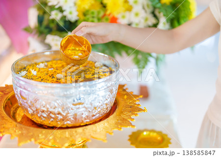 Happy Songkran festival day in Thailand or Thai Happy New Year. hand pouring water on golden Buddha statue with flowers and garland in. Holiday and culture concept 138585847