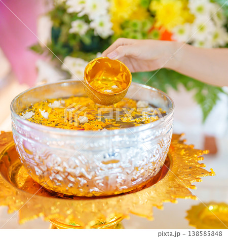 Happy Songkran festival day in Thailand or Thai Happy New Year. hand pouring water on golden Buddha statue with flowers and garland in. Holiday and culture concept Happy Songkran festival day in Thailand or Thai Happy New Year. hand pouring water on golden Buddha statue with flowers and garland in. Holiday and culture concept 138585848