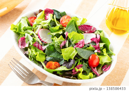 テーブルの上の野菜サラダとオリーブオイル 138586433