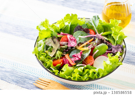 テーブルの上の野菜サラダとオリーブオイル 138586558