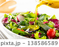 野菜サラダにオリーブオイルを掛ける 138586589