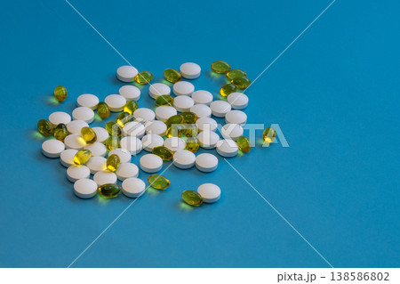White tablets and yellow gel capsules pile White tablets and yellow gel capsules pile 138586802