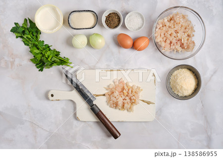 Preparing ingredients for a meal with fish, vegetables, and eggs on a kitchen counter 138586955