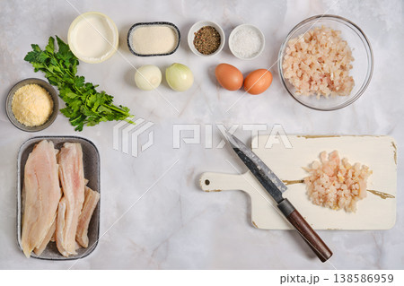 Preparing ingredients for a meal featuring fish and other foods in a kitchen setting Preparing ingredients for a meal featuring fish and other foods in a kitchen setting 138586959