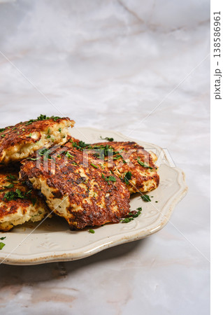 Fish patties served on a platter with herbs in a simple kitchen setting 138586961