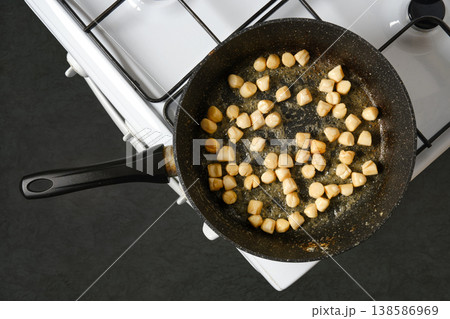 Cooking scallops in a frying pan on a stove in a kitchen 138586969