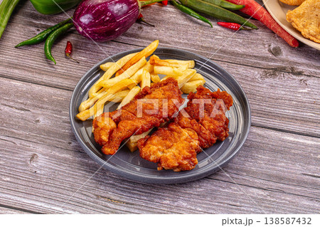 Crispy Fried Fish Fillets and French Fries on a Rustic Wooden Table with Fresh Vegetables Crispy Fried Fish Fillets and French Fries on a Rustic Wooden Table with Fresh Vegetables 138587432