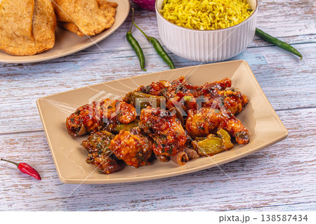 Plate of spicy glazed breaded prawn stir-fry with bell peppers and a side of yellow rice 138587434