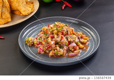 Spicy peanut and red onion salsa with cilantro and chili, served with fried chips. Spicy peanut and red onion salsa with cilantro and chili, served with fried chips. 138587439