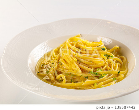 Italian linguine pasta with creamy lemon sauce and herbs in an elegant white bowl, isolated on a white background. 138587442