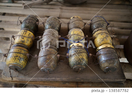 A collection of vintage M59 fragmentation grenades, likely from the Vietnam War era, displayed on a wooden surface A collection of vintage M59 fragmentation grenades, likely from the Vietnam War era, displayed on a wooden surface 138587782