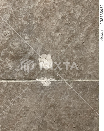 Damaged Porcelain Tile Surface With White Plaster Repair Mark 138588080