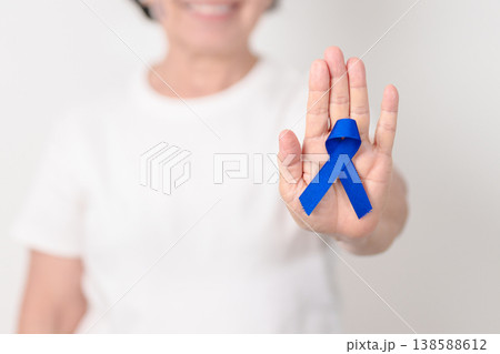 Elderly with dark Blue or Navy blue Ribbon for concept of March Colorectal and Colon Cancer Awareness month, May Arthritis awareness, July Juvenile arthritis and Childhood. Health and world cancer day 138588612