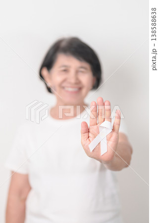 Elderly with White ribbon for concept November Lung Cancer Awareness month, Stop Violence Against Women, Adoption, May Retinoblastoma, Action for Women Health, March Remembrance, October Osteoporosis 138588638
