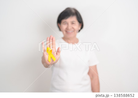 Elderly with Yellow Ribbon for concept of yellow September, Suicide prevention day, Childhood, July Sarcoma, bone and bladder cancer Awareness month, support survivor. Healthcare and World Cancer day 138588652