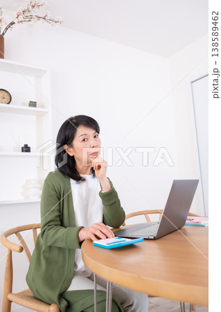 リビングで家計簿をつける50代主婦 138589462