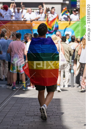 Person wrapped in rainbow flag walking 138589520