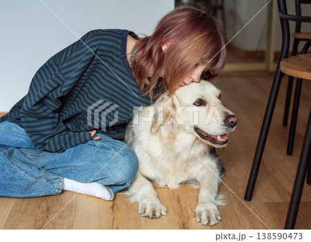 Young woman showing affection to golden retriever dog 138590473