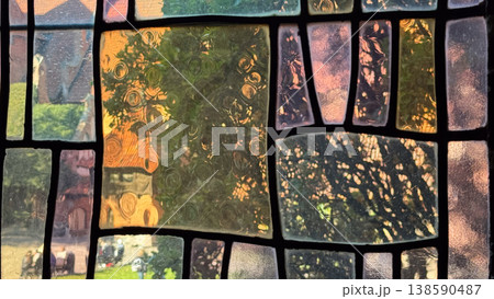 Close view of ancient stained glass window inside Malbork Castle in Poland showing textured panes and abstract patterns with exterior light. Architecture, history and heritage concept 138590487