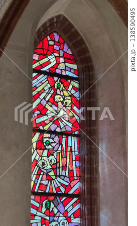 Close up of stained glass window with red dominant pattern inside Malbork Castle Poland. Light, color and abstract design concept 138590495