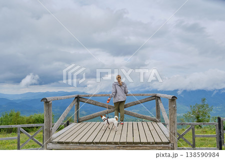 Traveler with Dog Looking at Mountain Vista from Deck Traveler with Dog Looking at Mountain Vista from Deck 138590984