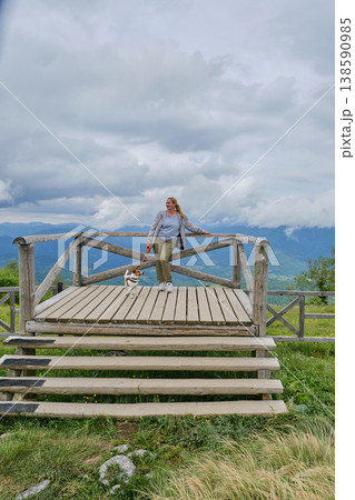 Happy Woman with Jack Russell Terrier on Mountain Viewpoint 138590985