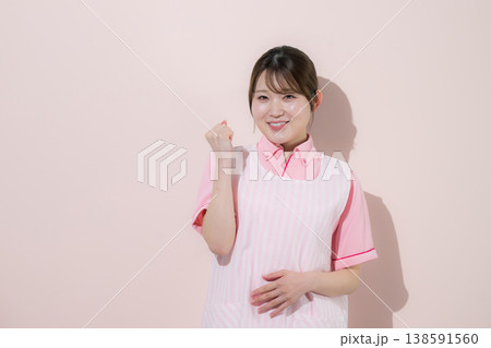 ピンク背景で介護士や保育士として働く女性の訪問介護とやりがいある仕事のイメージ 138591560