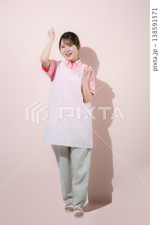 ピンク背景で介護士や保育士として働く女性の訪問介護とやりがいある仕事のイメージ ガッツポーズでやる気 ピンク背景で介護士や保育士として働く女性の訪問介護とやりがいある仕事のイメージ ガッツポーズでやる気 138591571