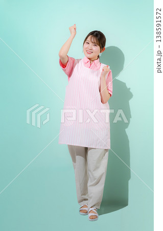グリーン背景で介護士や保育士として働く女性の訪問介護とやりがいある仕事のイメージ グリーン背景で介護士や保育士として働く女性の訪問介護とやりがいある仕事のイメージ 138591572