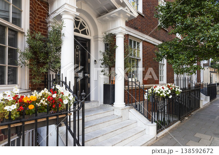 Elegant brick townhouse exterior with white pillars and flower boxes 138592672