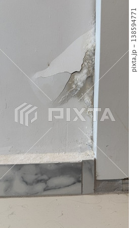 Cracked wall corner with visible damage and exposed white material, suitable for background 138594771