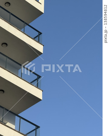 Modern architectural facade with geometric design against clear blue sky, ideal background image Modern architectural facade with geometric design against clear blue sky, ideal background image 138594812