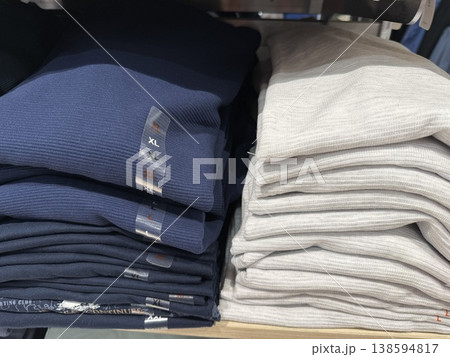 Folded clothes on store shelf showing various colors and sizes for fashion retail display Folded clothes on store shelf showing various colors and sizes for fashion retail display 138594817