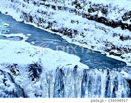 Close-up of frozen Gullfoss waterfall edge with turquoise river water in winter, Iceland. Close-up of frozen Gullfoss waterfall edge with turquoise river water in winter, Iceland. 138594917
