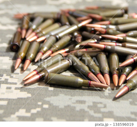 Cartridges for Kalashnikov assault rifle. War Concept. Heap of billets Cartridges for Kalashnikov assault rifle. War Concept. Heap of billets 138596019