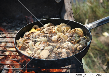 Cooking fried mussels in frying pan. Frying fresh mussels and onions Cooking fried mussels in frying pan. Frying fresh mussels and onions 138596162