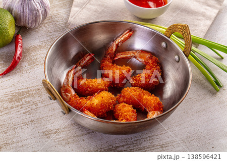 Crispy fried shrimp in a rustic pan with sweet chili sauce, lime, and garlic 138596421